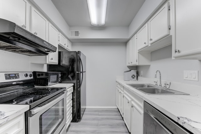 kitchen with white cabinets, light stone counters, light hardwood / wood-style flooring, sink, and stainless steel appliances