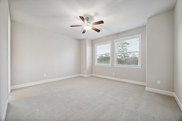 spare room with light colored carpet and ceiling fan