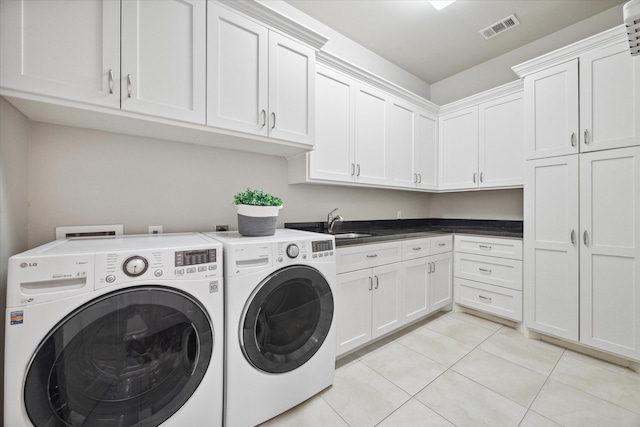 laundry area with sink, washer and dryer, cabinets, and light tile patterned floors