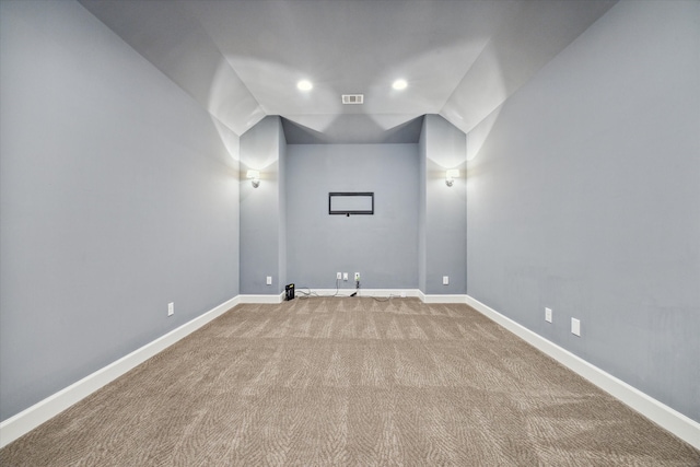 carpeted empty room with lofted ceiling