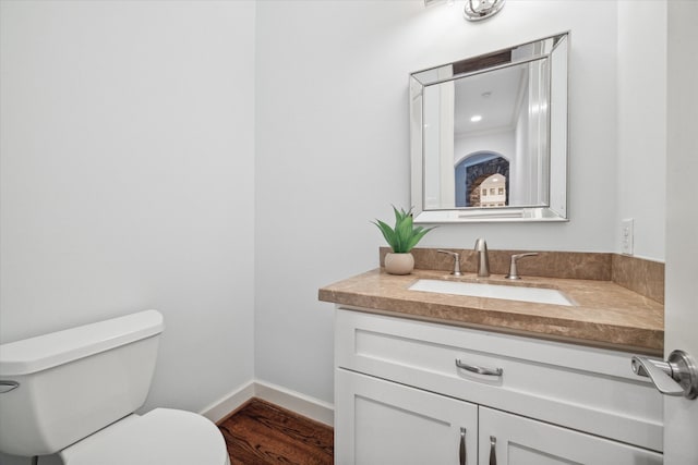 bathroom with vanity, toilet, and hardwood / wood-style floors