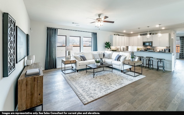 living room featuring ceiling fan and light hardwood / wood-style flooring