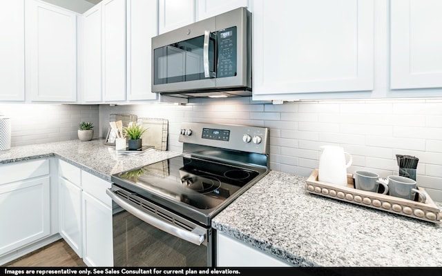 kitchen featuring appliances with stainless steel finishes, white cabinets, and hardwood / wood-style floors