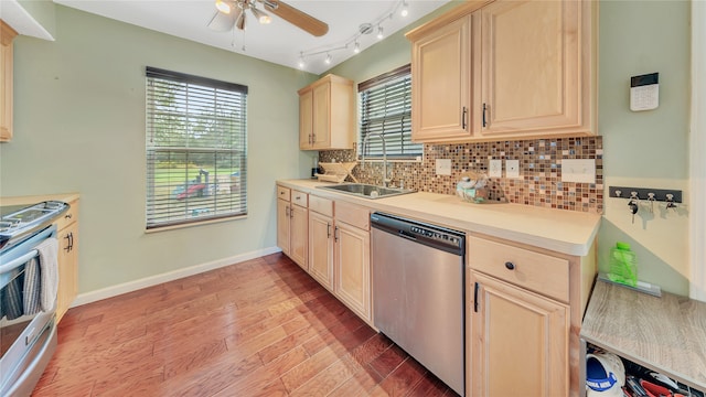 kitchen with sink, light brown cabinets, stainless steel appliances, backsplash, and light hardwood / wood-style floors