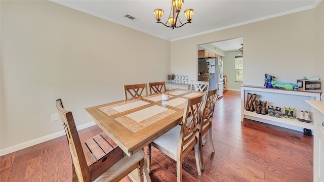 dining area with wood-type flooring, ceiling fan with notable chandelier, and ornamental molding