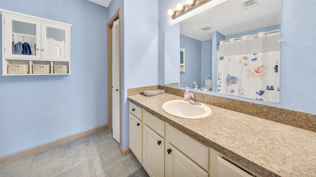 bathroom with vanity, curtained shower, and toilet