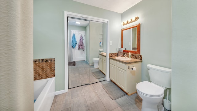 bathroom with a bathing tub, vanity, and toilet