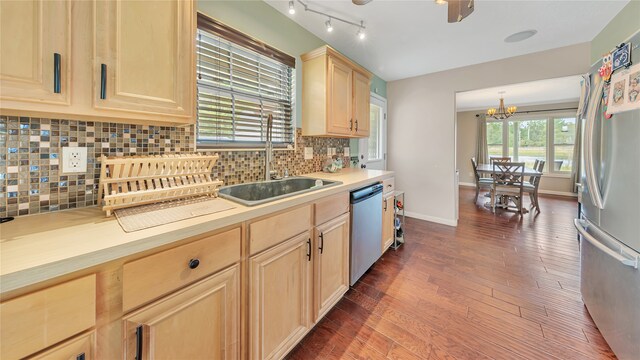 kitchen featuring pendant lighting, light brown cabinets, tasteful backsplash, a notable chandelier, and stainless steel appliances