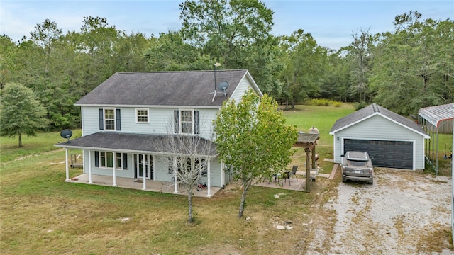 view of front of house featuring a porch, an outbuilding, a front yard, and a garage