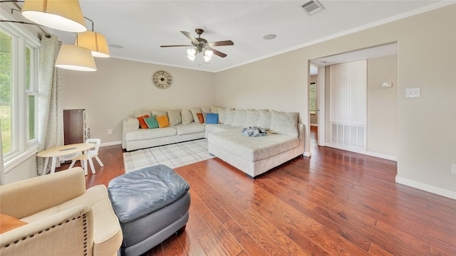 living room featuring dark hardwood / wood-style floors, ceiling fan, and crown molding