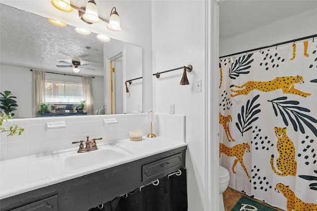 bathroom featuring toilet, a shower with curtain, vanity, a textured ceiling, and ceiling fan