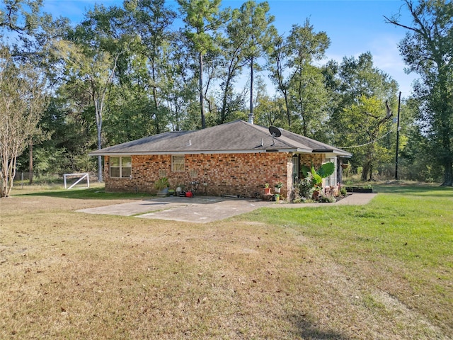 view of home's exterior with a patio area and a lawn