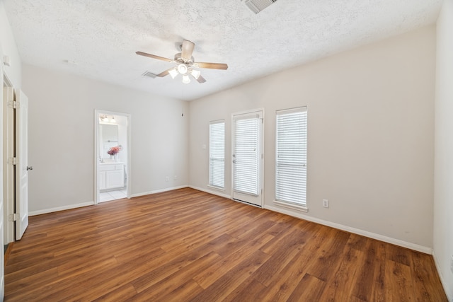 empty room with dark hardwood / wood-style flooring, a textured ceiling, and ceiling fan