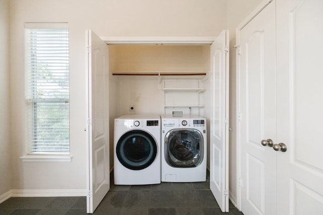 laundry room featuring dark tile patterned flooring and washer and dryer