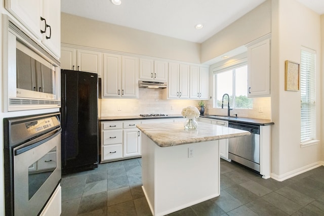 kitchen featuring tasteful backsplash, a center island, white cabinets, and stainless steel appliances