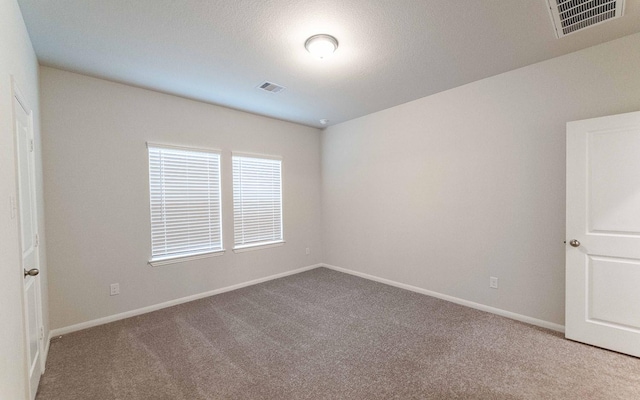 carpeted spare room featuring a textured ceiling