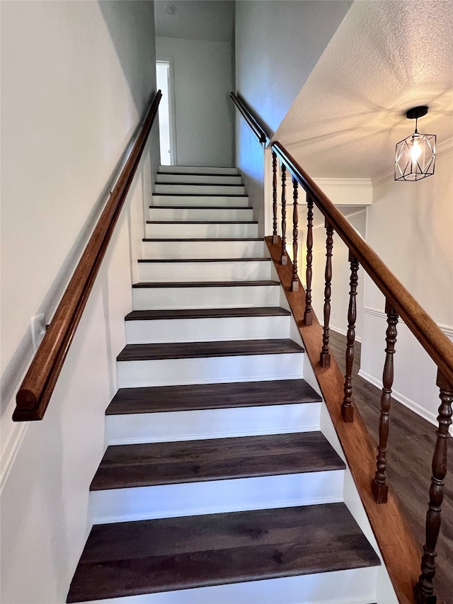 staircase with a textured ceiling