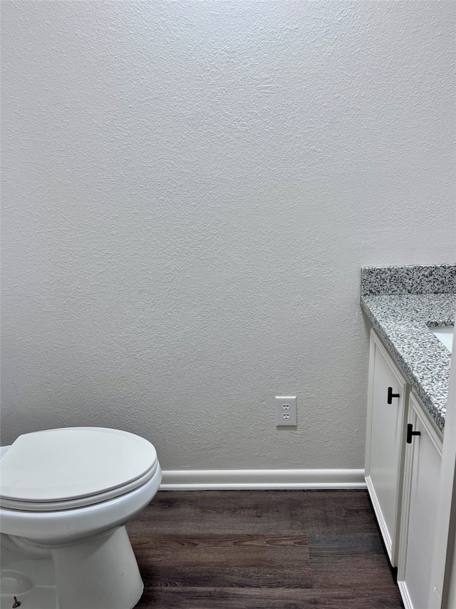 bathroom featuring vanity, hardwood / wood-style flooring, and toilet