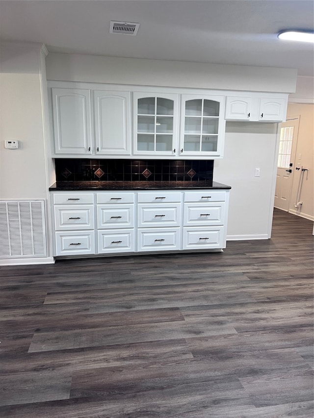 kitchen featuring dark wood-type flooring, tasteful backsplash, and white cabinets