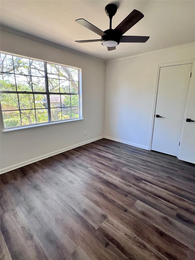 empty room with dark wood-type flooring, crown molding, and ceiling fan