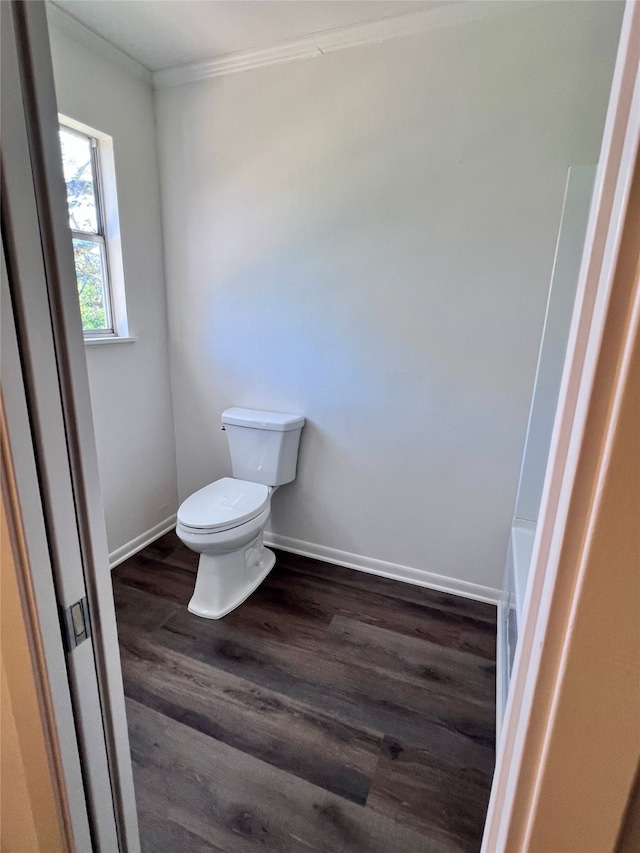 bathroom featuring toilet, hardwood / wood-style flooring, and ornamental molding