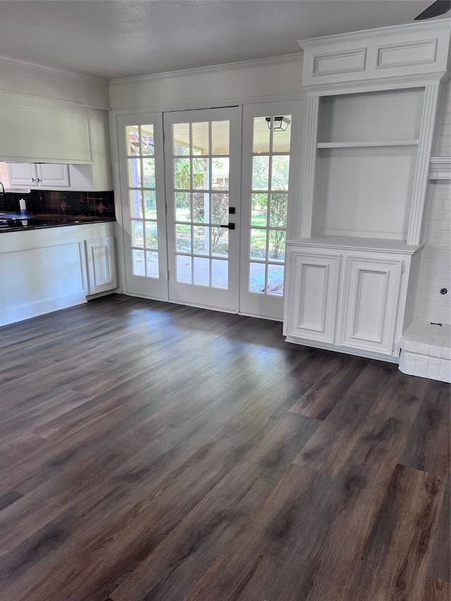 interior space featuring french doors, built in features, dark hardwood / wood-style flooring, and ornamental molding