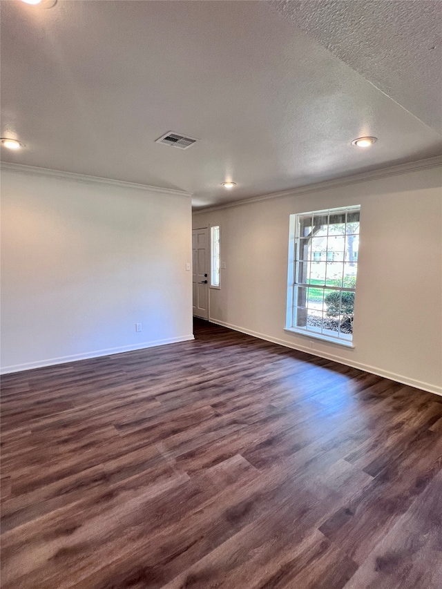 empty room with ornamental molding, a textured ceiling, and dark hardwood / wood-style flooring