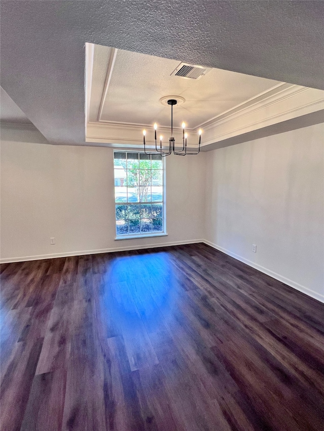 unfurnished dining area featuring ornamental molding, dark hardwood / wood-style floors, a textured ceiling, and a raised ceiling