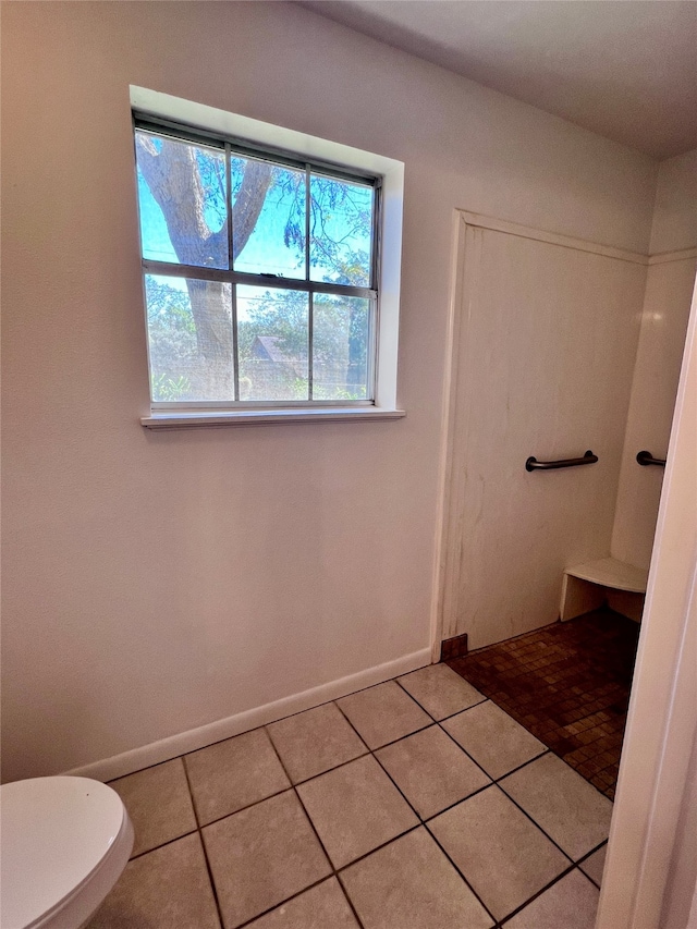 bathroom with toilet and tile patterned flooring