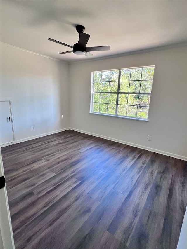 empty room with crown molding, dark wood-type flooring, and ceiling fan