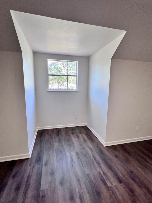 bonus room featuring a textured ceiling and dark hardwood / wood-style flooring