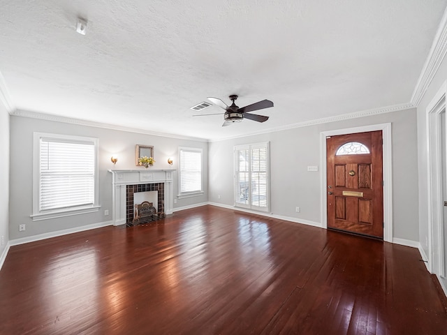 unfurnished living room with a tiled fireplace, ornamental molding, and dark hardwood / wood-style floors