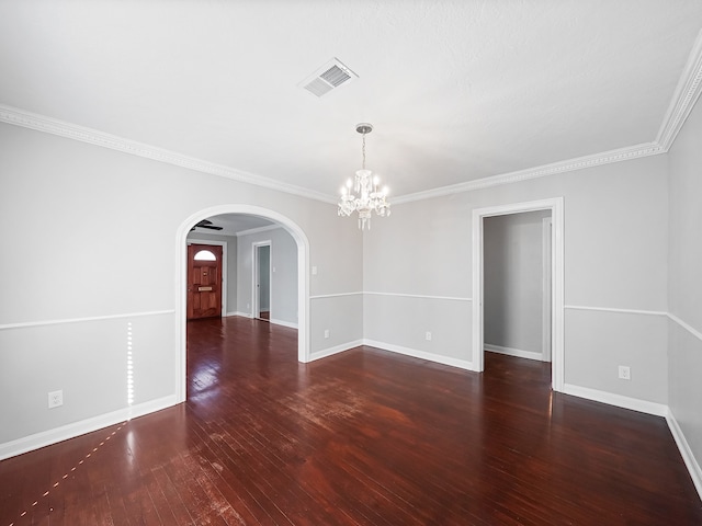 spare room with a notable chandelier, dark hardwood / wood-style floors, and crown molding