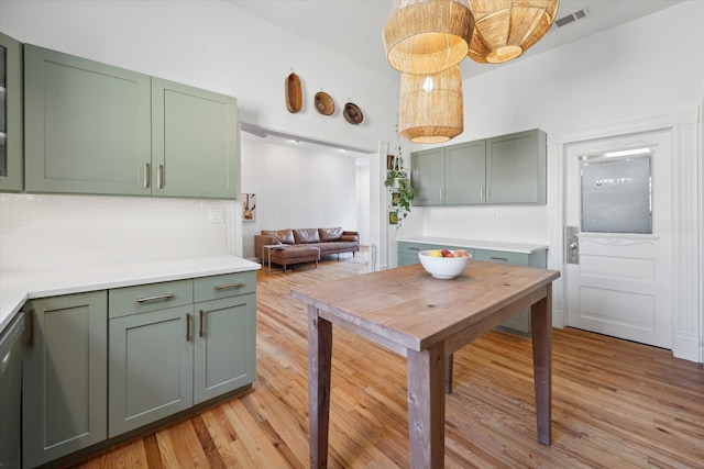 kitchen featuring backsplash, green cabinetry, and light hardwood / wood-style floors