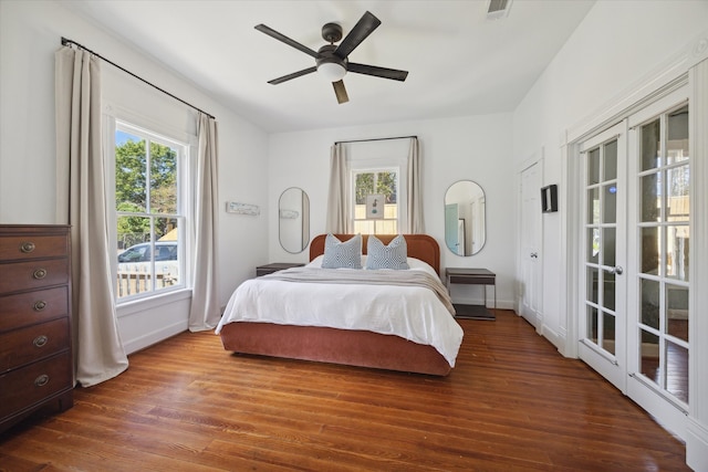 bedroom with dark hardwood / wood-style flooring, multiple windows, and ceiling fan