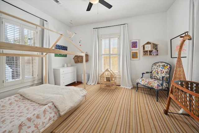 bedroom with light hardwood / wood-style floors and ceiling fan