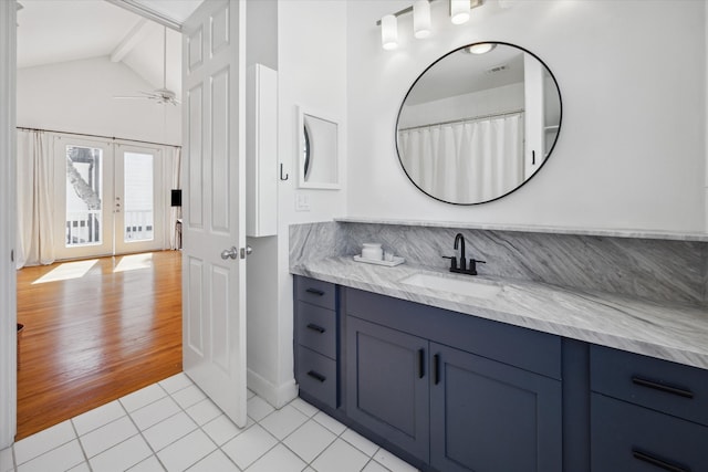 bathroom with ceiling fan, hardwood / wood-style flooring, vanity, french doors, and lofted ceiling with beams