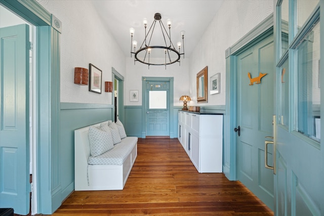 doorway with dark hardwood / wood-style flooring and a chandelier