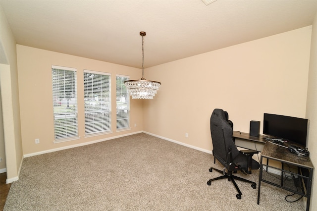 carpeted office with an inviting chandelier