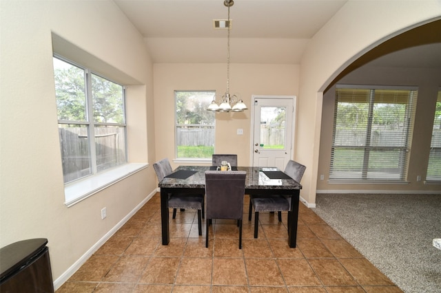 dining room featuring lofted ceiling, a healthy amount of sunlight, and carpet