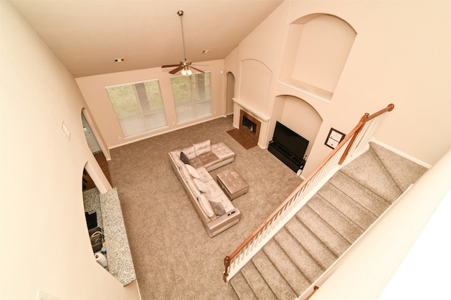 living room featuring ceiling fan, carpet, and vaulted ceiling