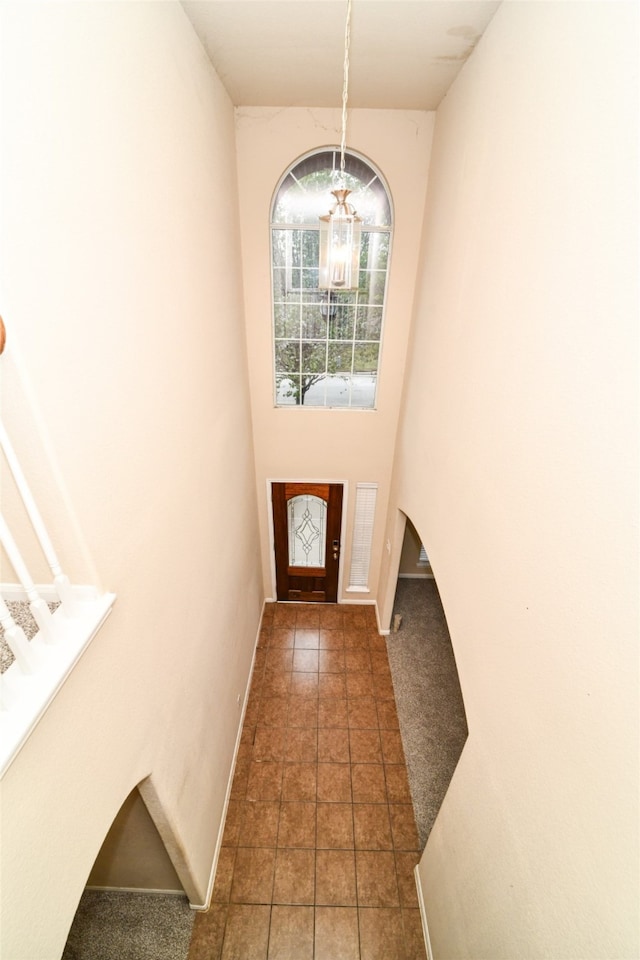 doorway to outside featuring dark tile patterned floors and a chandelier