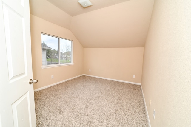 additional living space featuring carpet flooring and lofted ceiling