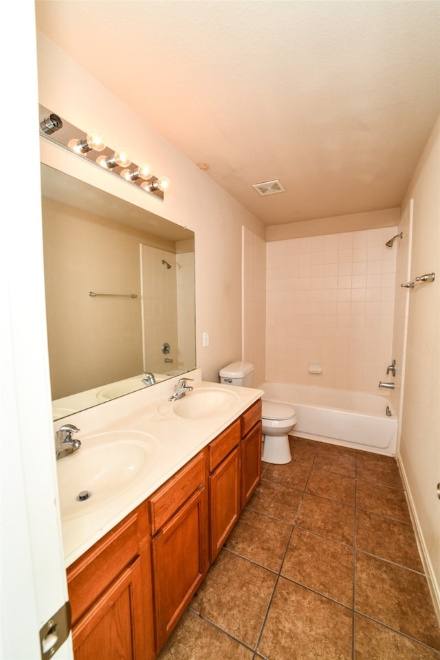 full bathroom with tiled shower / bath, vanity, toilet, and tile patterned floors