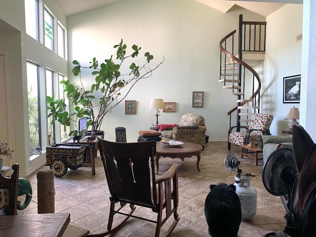 living area featuring high vaulted ceiling, stairway, baseboards, and light tile patterned floors