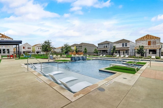 view of swimming pool with pool water feature and a patio area