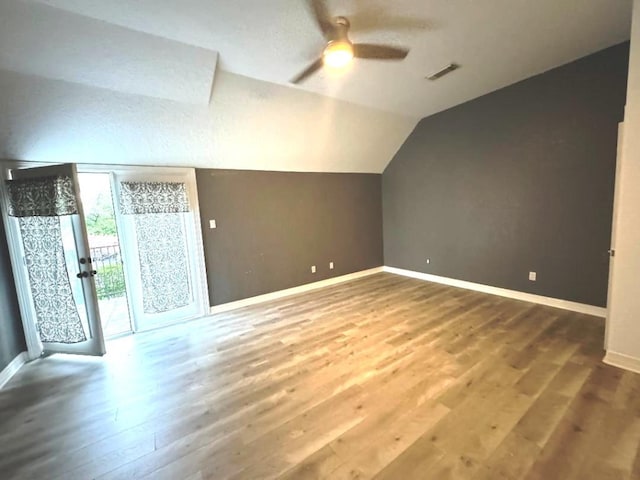 bonus room with a textured ceiling, ceiling fan, wood-type flooring, and vaulted ceiling