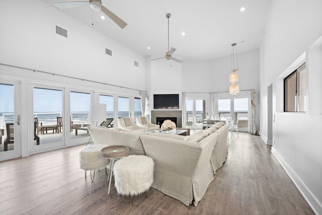 living room with ceiling fan, high vaulted ceiling, and hardwood / wood-style flooring