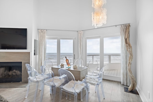 dining room featuring a water view, light hardwood / wood-style floors, and a notable chandelier