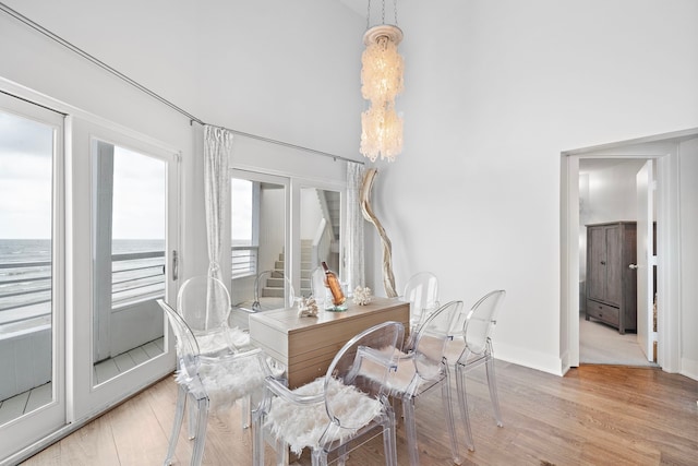 dining area featuring a water view and light hardwood / wood-style flooring